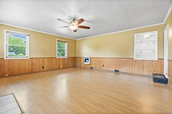 This bright living space features wood flooring and a refreshing ceiling fan for comfort.