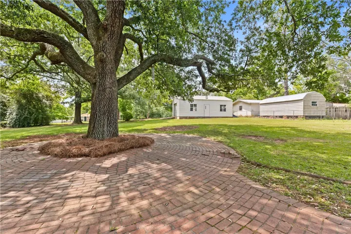 Mature trees and brick paving create a welcoming ambiance for this outdoor space.