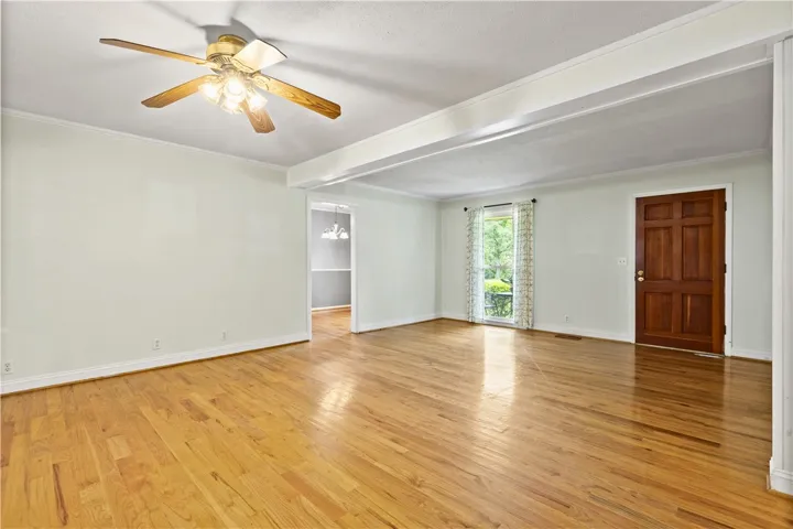 This bright living space features polished hardwood floors, offering a welcoming atmosphere for daily living.