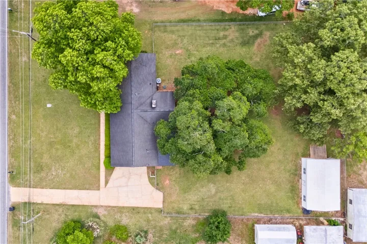 Aerial view of a home nestled among mature trees with expansive grounds.