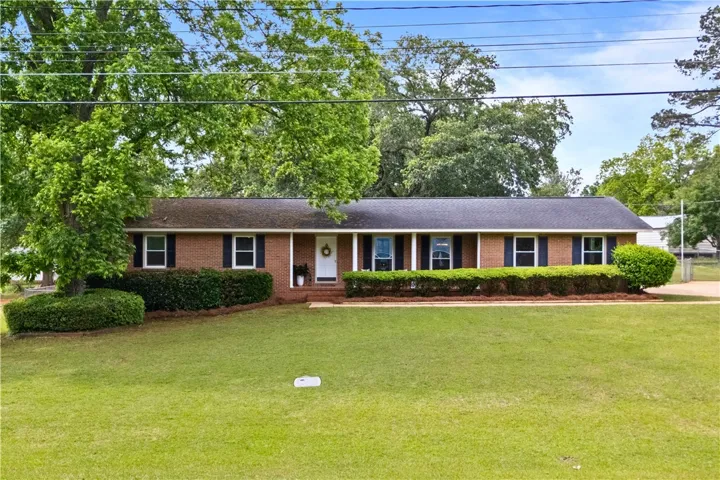This classic brick ranch home offers timeless charm and a verdant lawn.
