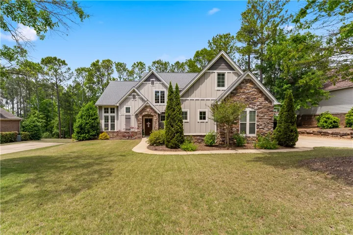 This charming residence features a classic architectural style with natural stone and siding accents.
