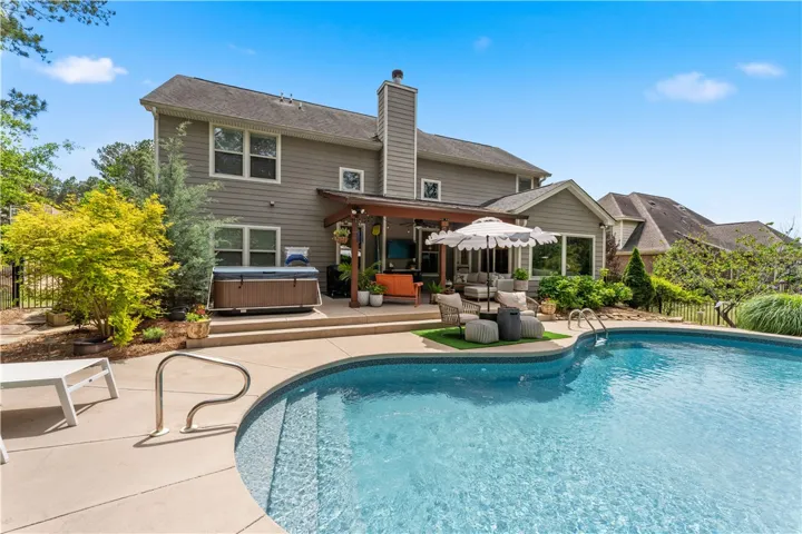 This outdoor oasis features a refreshing pool, ample patio space, and lush landscaping.