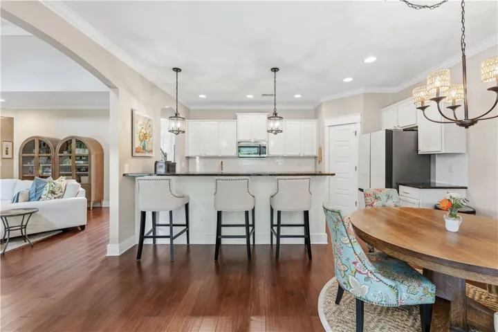 This open concept kitchen and dining area features abundant natural light and rich wood flooring.