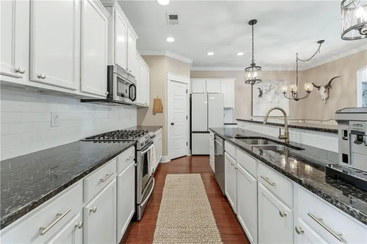 This sleek kitchen features ample counter space, modern appliances, and stylish lighting fixtures.