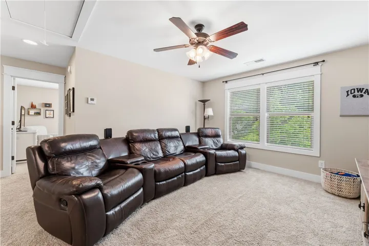 This inviting media room features comfortable seating and ample natural light, creating an ideal setting for relaxation.