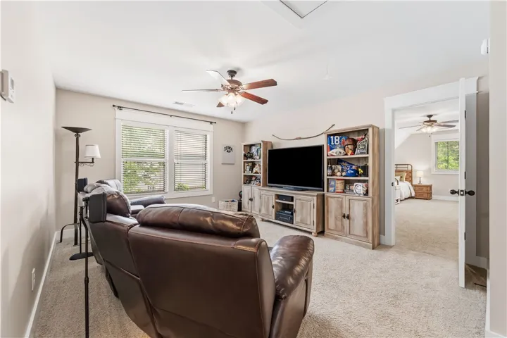 This inviting living space features cozy carpeting and a doorway leading to a tranquil bedroom.