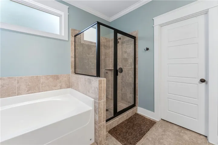 This bathroom features a contemporary shower and a relaxing tub, creating a serene personal retreat.