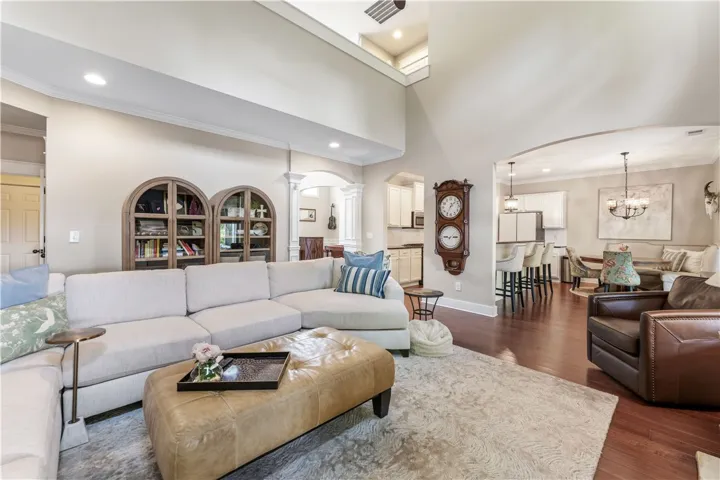 This bright living area features vaulted ceilings and hardwood flooring, flowing into an eat-in kitchen.