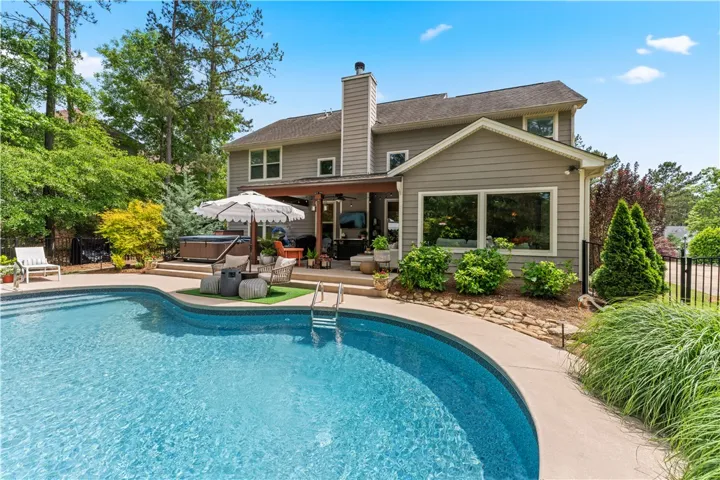 This serene backyard oasis features a sparkling pool and a welcoming patio area, perfect for outdoor enjoyment.