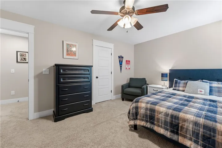 This cozy bedroom features comfortable carpeting and a ceiling fan, perfect for restful nights.