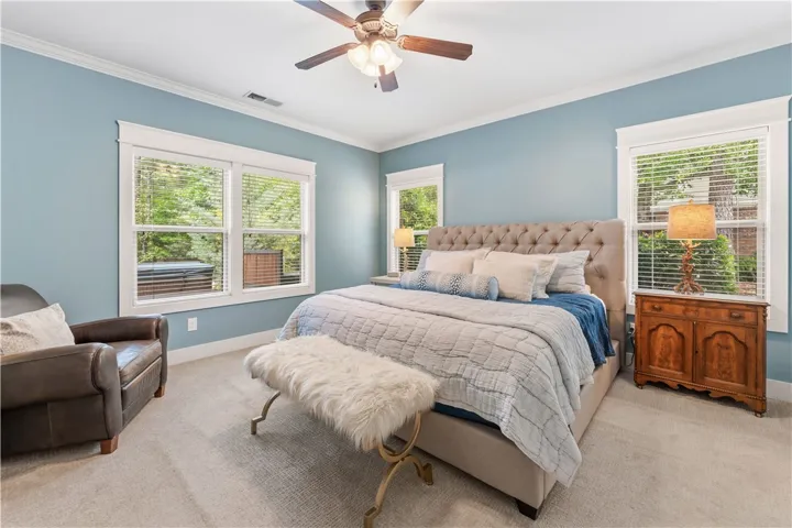 This spacious primary bedroom offers comfort with ample natural light filtering through multiple windows.