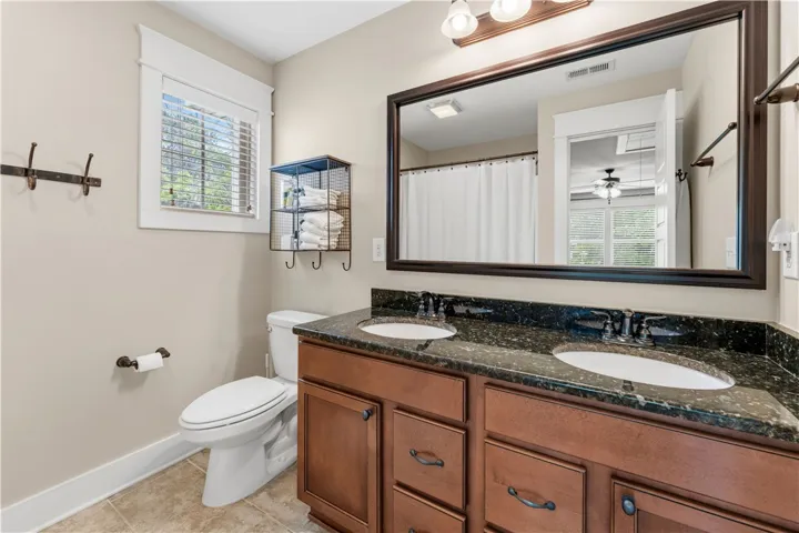 This bright bathroom features a spacious dual-sink vanity and warm lighting, perfect for daily routines.