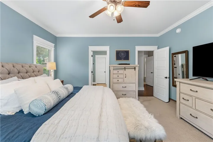 This spacious primary bedroom features soft hues, elegant trim, and abundant natural light.