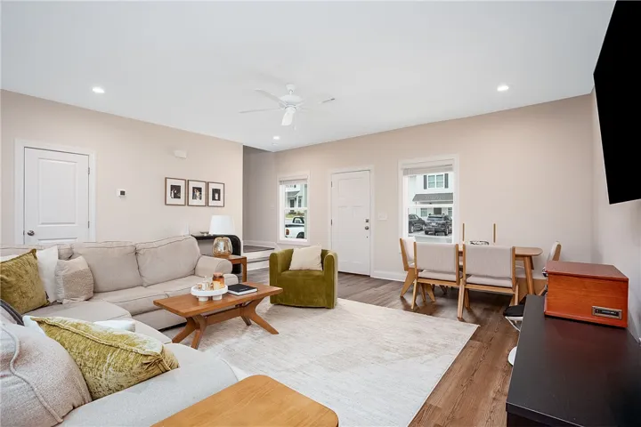 This inviting living area boasts rich hardwood floors and recessed lighting, perfect for everyday living and entertaining.
