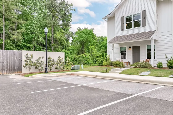 This residence features a crisp white facade with a welcoming covered entry and private parking.