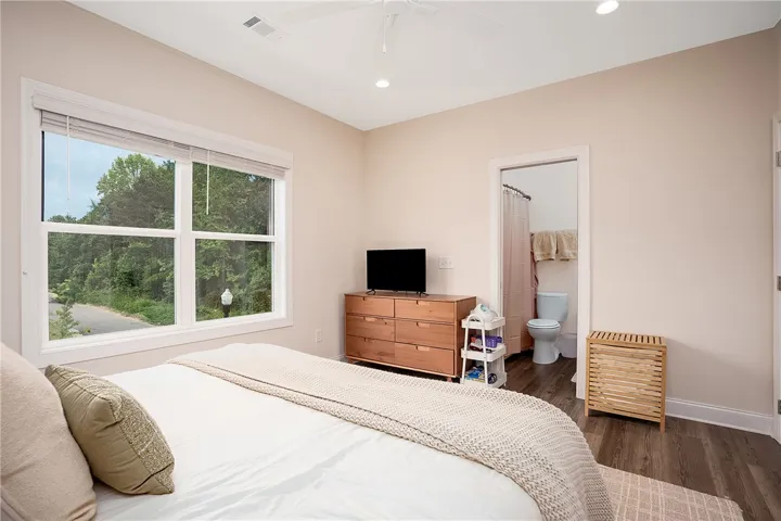 This serene bedroom offers ample light and private bath, ensuring a tranquil personal retreat.