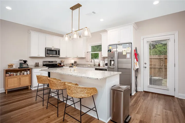 This bright kitchen features an island, ample counter space, and direct outdoor access.