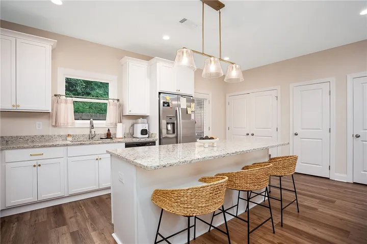 This bright kitchen features sleek appliances, ample counter space, and convenient island seating.