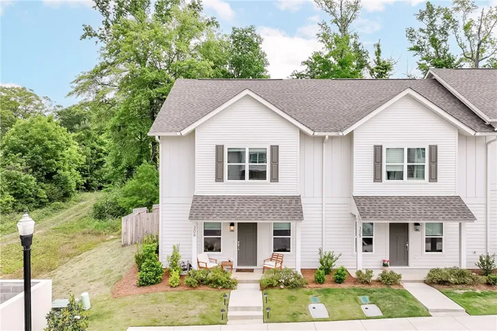 This charming modern townhouse boasts crisp white siding and inviting covered front porches.