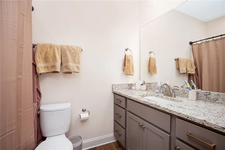 This bathroom features elegant granite counters and a spacious vanity with ample storage.