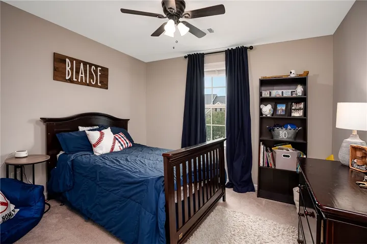 This cozy bedroom features warm walls and a classic wooden bed, creating a comfortable and inviting atmosphere.