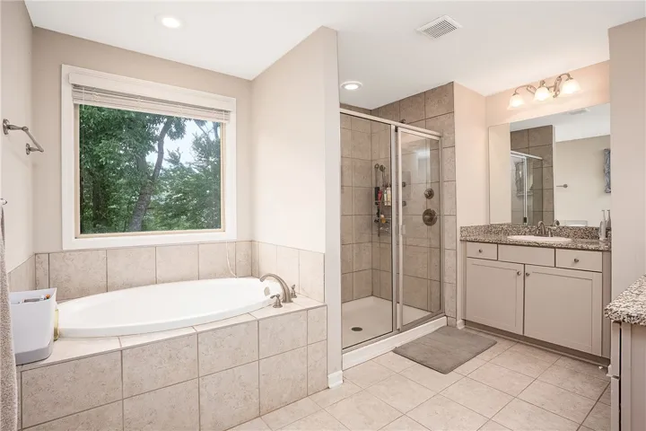 This spacious bathroom offers a relaxing soaking tub and a refreshing shower, perfect for unwinding.