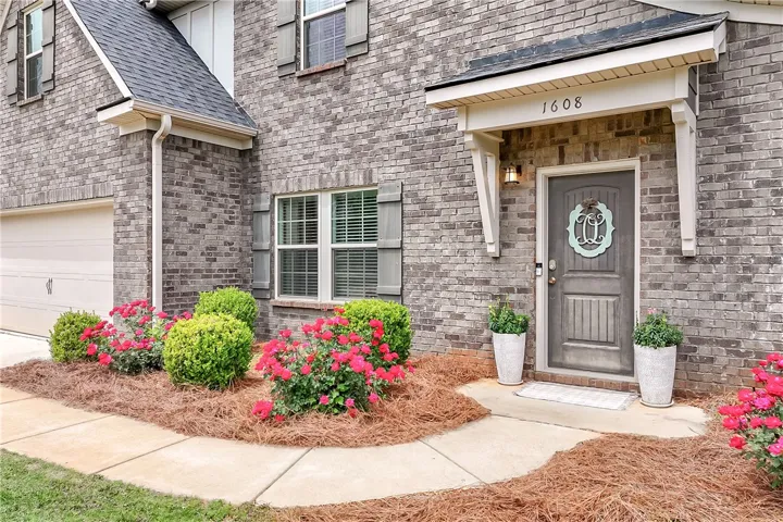 The home features an inviting entrance with a well-maintained lawn and beautiful landscaping.