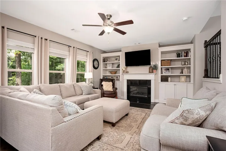 This inviting living space features elegant built-in shelving, a cozy fireplace, and ample natural light.