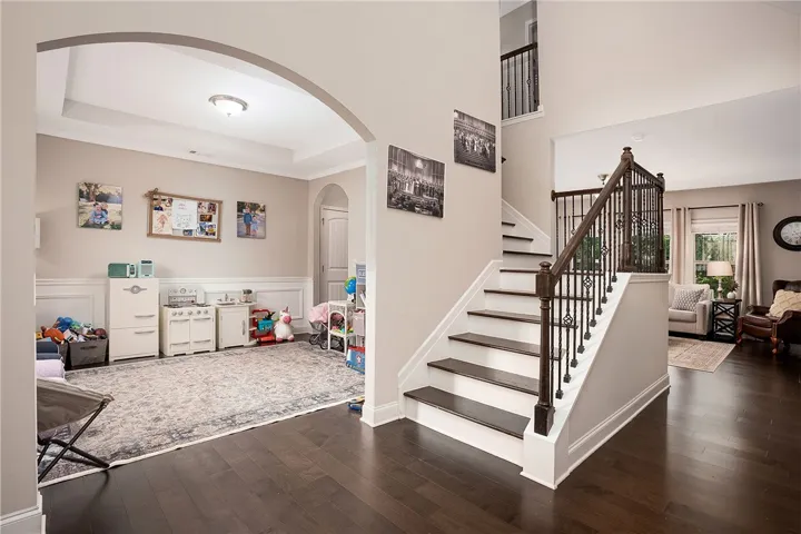 This inviting interior features a grand staircase and beautiful hardwood floors throughout the living spaces.