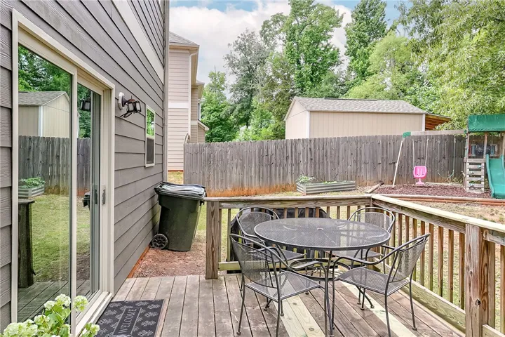 This inviting outdoor deck offers space for dining, complemented by a fenced yard and handy shed.