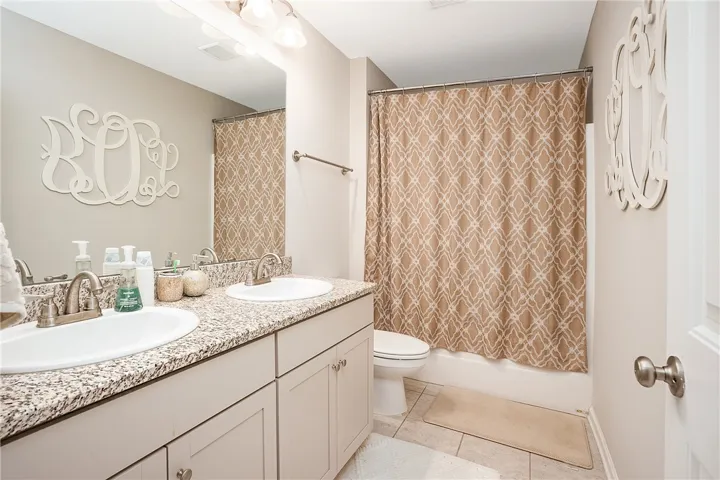 This bathroom features dual sinks and ample counter space, perfect for daily routines.