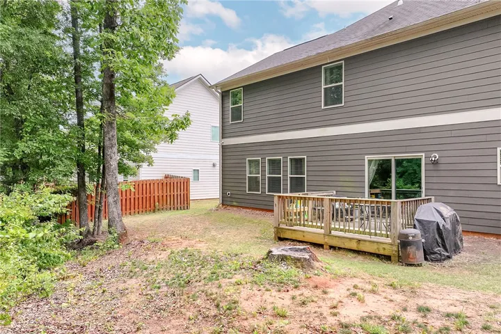 This spacious backyard features a wooden deck, perfect for outdoor enjoyment.