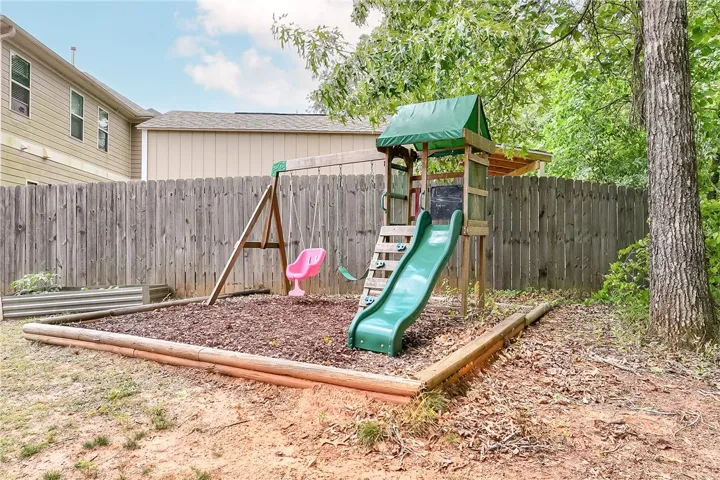 This spacious yard features a vibrant playground, perfect for outdoor activities and family enjoyment.