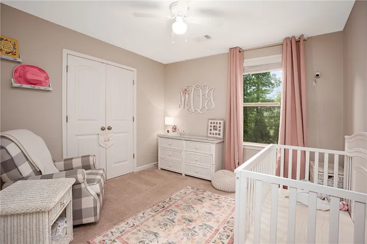 This cozy bedroom features warm tones and ample natural light, creating a serene environment.