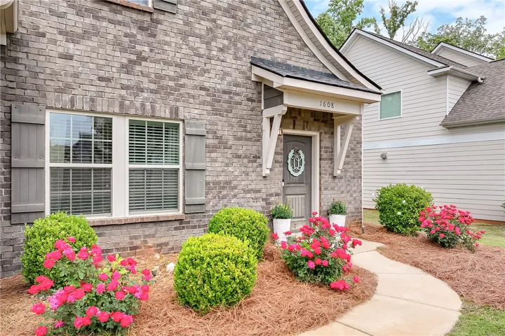 This charming home showcases a brick and siding exterior with attractive landscaping.