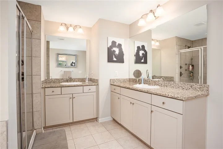 This spacious bathroom offers dual vanities, generous counter space, and a tiled​​‌​​​​‌​​‌‌​‌‌​​​‌‌​‌​‌​‌​​​‌​​ shower.
