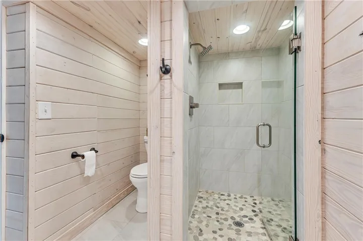 This bathroom showcases a modern walk-in shower and convenient toilet area.
