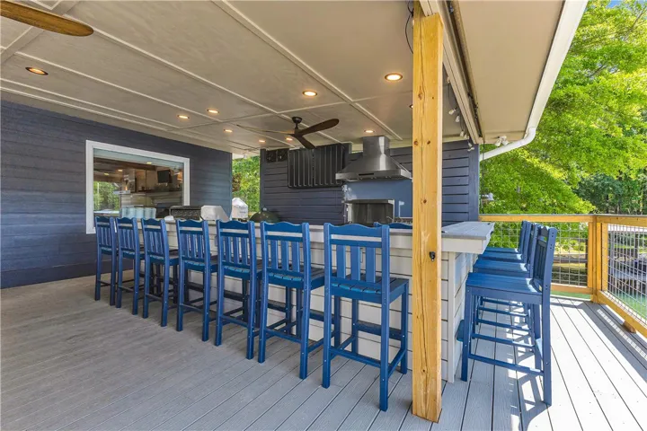 An inviting outdoor kitchen and bar area provides the perfect space for al fresco entertaining.