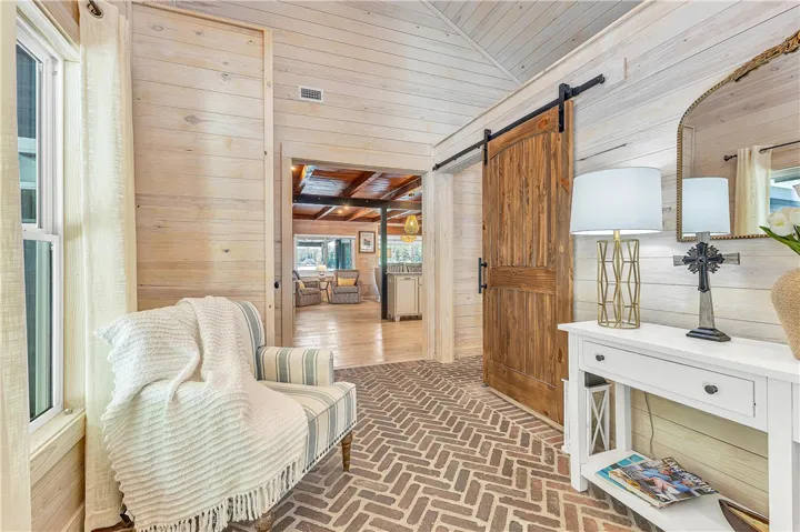 This inviting entry features natural wood tones and durable brick flooring, welcoming all who enter.