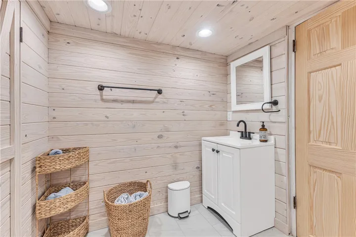 This bathroom features pristine wood paneling, a sleek vanity, and modern fixtures, creating a serene atmosphere.