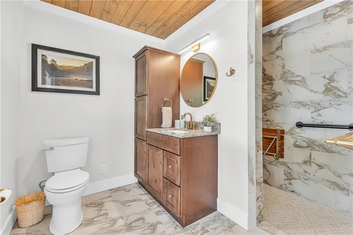 This bright bathroom features a stylish vanity, a contemporary toilet, and a spacious shower.