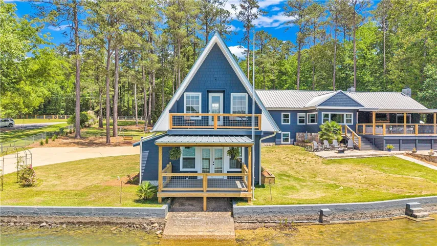 This lakeside home features a striking blue exterior, private yard, and multi-level decks for serene waterfront living.