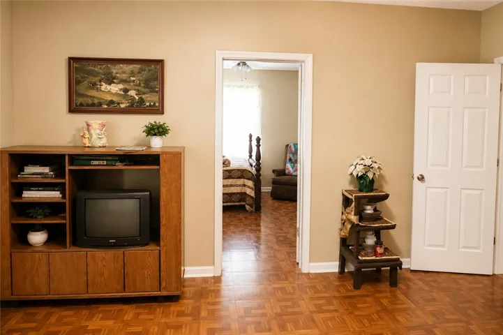 This interior offers classic wood flooring, leading to a cozy bedroom.