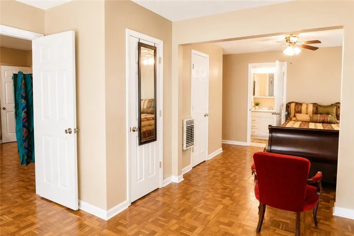 This interior offers classic wood flooring, a ceiling fan, and convenient access to a bathroom.