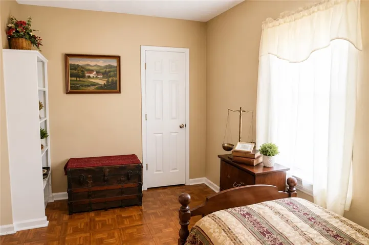 This cozy bedroom features warm tones and elegant flooring, creating a comfortable and inviting atmosphere.