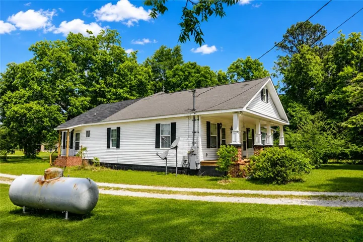 Charming home with classic architecture and expansive green surroundings offers a peaceful retreat.