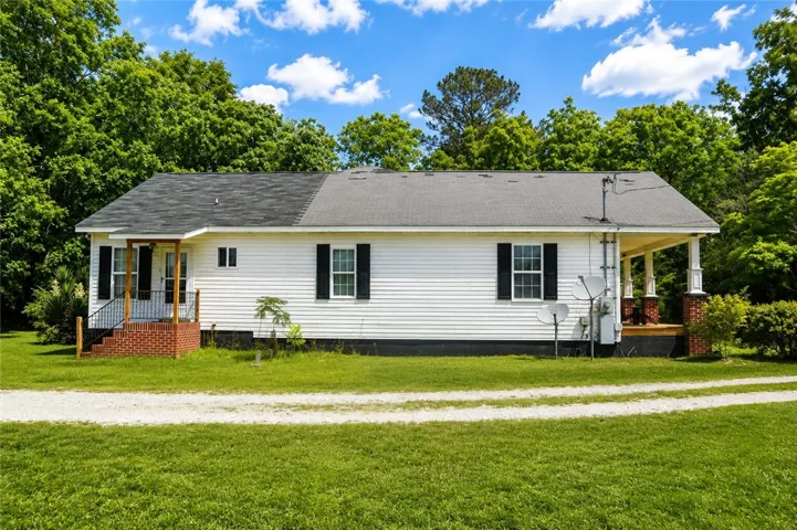 This charming residence features a well-maintained exterior, offering a blend of comfort and natural surroundings.