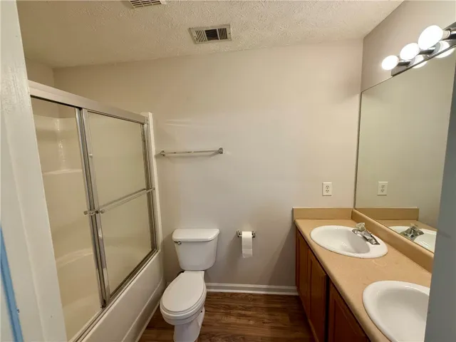 This bathroom features a double vanity and a shower-tub combination for comfort.