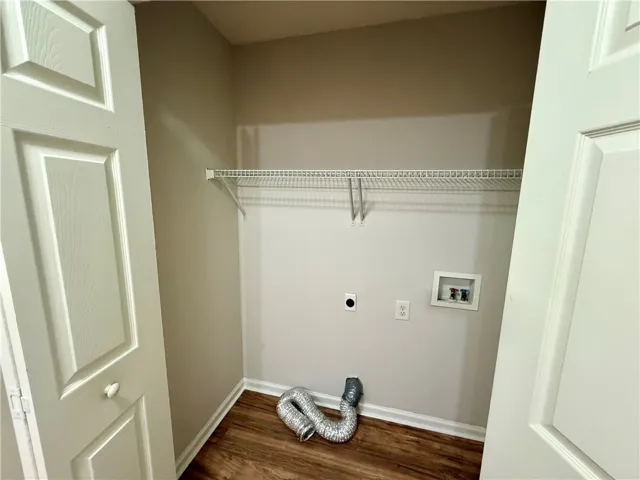 This dedicated laundry closet features convenient hookups and practical shelving.